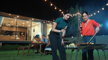 Family gather celebrate holiday. Focus Mother and grandmother drink wine and grill food for family...