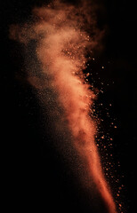 red and brown color powder dispersion, diagonally in black background