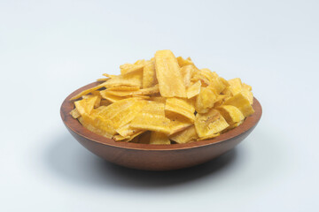 Studio shot of female hands picking Indian snack banana wafers from a scarved wooden bowl, isolated on white