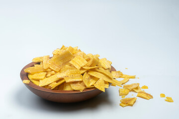 Studio shot of Indian snack banana wafers from a shallow disposable cardboard plate isolated on white