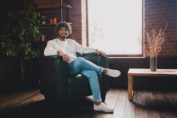 Photo of funky cool guy dressed white pullover sititng sofa relaxing home indoors house apartment...