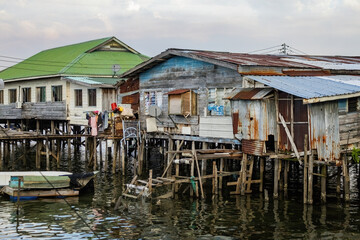 Fishing village houses over the water garbage poor areas in Sabah province in Malaysia