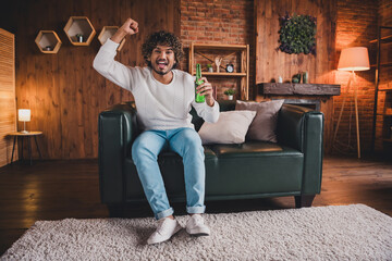Obraz premium Photo of cheerful excited guy dressed white pullover watch fottball enjoying beer staying home indoors house apartment room