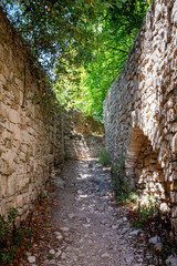 Fototapeta premium A narrow pathway between two stone wall in Provence, France