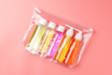 Clear Plastic Bag Containing Travel-Sized Toiletries on Pink Background