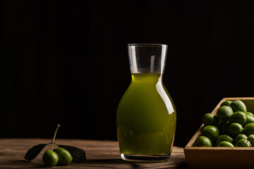 Extra virgin olive oil in a glass bottle and green olives