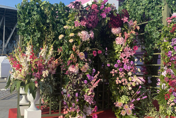 arch of pink flowers and green leaves, during the day at the flower festival. Floristry, exclusive solution for the holiday, painstaking work, fresh flowers