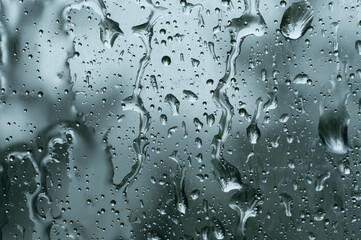 Big raindrops on window glass in stormy weather