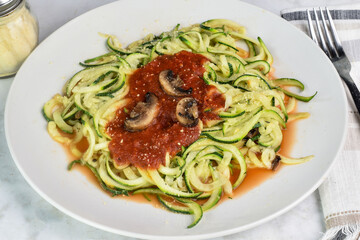 zucchini noodles top with sauce , mushrooms and  cheese