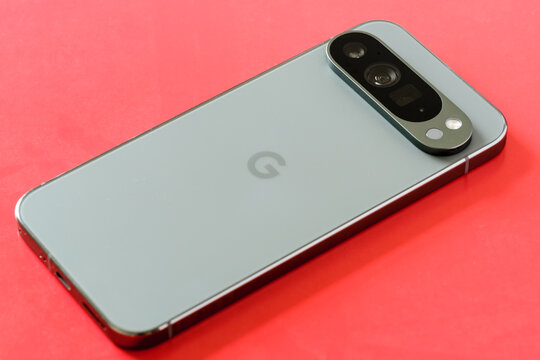 Back view of the Google Pixel 9 Pro XL in Hazel Green, highlighting the triple camera on a vibrant red background, Stafford, United Kingdom, August 22, 2024.