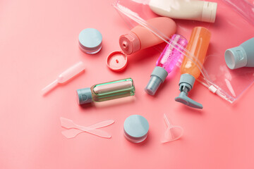 Clear Plastic Bag Containing Travel-Sized Toiletries on Pink Background
