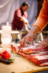 vertical man's hands preparing beef with salt and lemon for barbecue in latin america - barbecue concept