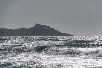 Fototapeta premium In Sardegna una spiaggia con la sabbia gialla e onde alte in estate.