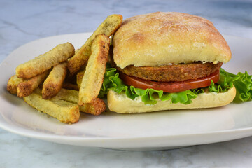 veggie burger  on a ciabatta  bun with veggie fries.