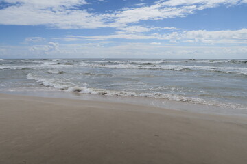 Wellen brechen halbkreisförmig am Strand von Sandhammaren in Ystad in Südschweden 