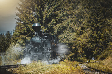 Historic steam locomotive in train station. Steam locomotive pump out clouds of smoke. Steam train with white smoke. Steam train on railway. Vintage steam train ride.