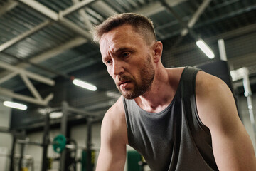 Fototapeta premium Low angle shot of exhausted man suffering from doms after intensive workout