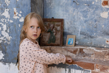 lonely little girl on the ruins of a brick building, destruction, disasters and wars