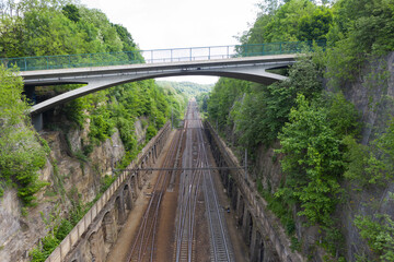 Aerial view shot by a drone of a road bridge over the railroad tracks. High quality photo. New road bridge over old railway. Summer day viaduct over the railway.