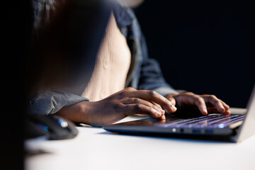 Close up of african american pair of hands typing on digital laptop keyboard, surfing the internet, online working, telecommuting, freelancer at work concept. Black person utilizing modern technology.