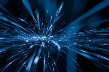 blue sparks from the grinder glowing in the dark