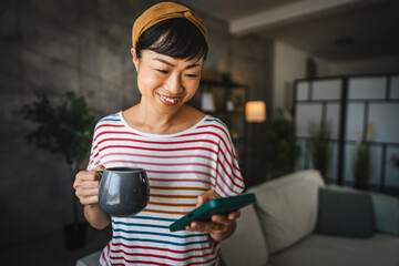 Mature japanese woman enjoy at her first coffee and use mobile phone