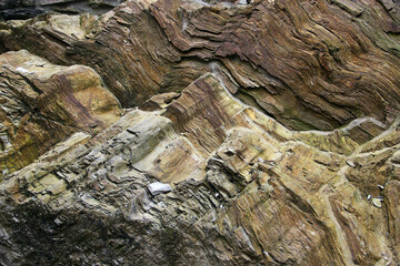 Layered rock formations with intricate stone textures, revealing the mountain's geological history....