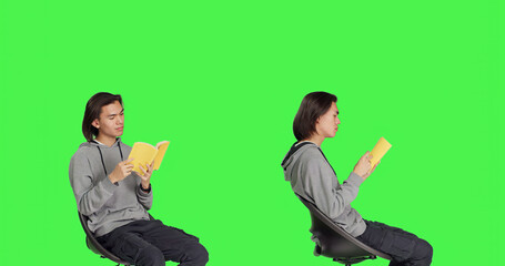 Asian person reading literature book over greenscreen backdrop, enjoying lecture while he sits on...