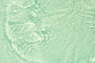 Blue water with ripples on the surface. Defocus blurred transparent blue colored clear calm water surface texture with splashes and bubbles. Water waves with shining pattern texture background.