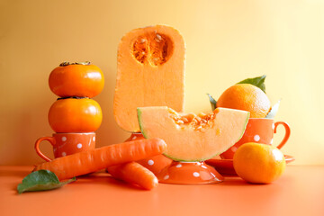 Orange fruit and vegetables with orange polka dot tableware, color blocking aesthetic. Orange foods contain beta carotene, an antioxidant that helps reduce inflammation in the body.