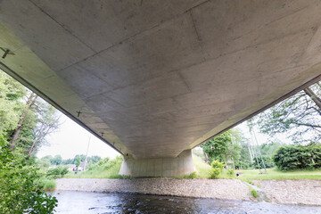 Reinforced concrete road bridge over the river. Close-up during sunny day in summer. Aerial view on...
