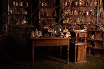 Halloween background Shelves with alchemy tools Skull spiderweb bottle with poison candles Witcher workspace Scarry room