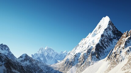 Naklejka premium Majestic mountain range with snow-capped peaks and clear blue sky above. Majestic Mountain Range
