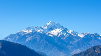 Fototapeta premium Majestic mountain range with snow-capped peaks and clear blue sky above. Majestic Mountain Range