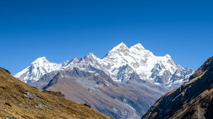 Fototapeta premium Majestic mountain range with snow-capped peaks and clear blue sky above. Majestic Mountain Range