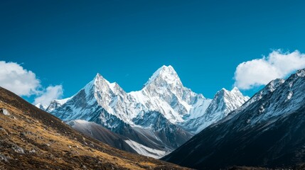 Obraz premium Majestic mountain range with snow-capped peaks and clear blue sky above. Majestic Mountain Range