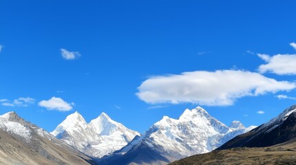Fototapeta premium Majestic mountain range with snow-capped peaks and clear blue sky above. Majestic Mountain Range