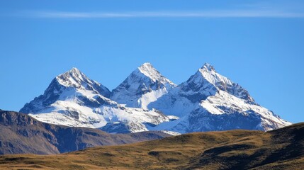 Majestic mountain range with snow-capped peaks and clear blue sky above. Majestic Mountain Range