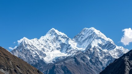 Obraz premium Majestic mountain range with snow-capped peaks and clear blue sky above. Majestic Mountain Range