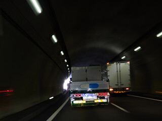 高速道路のトンネルの中で走行する車の風景