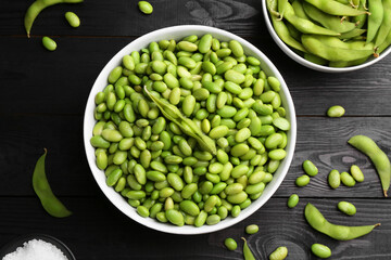 Raw green edamame soybeans and pods on wooden table, flat lay