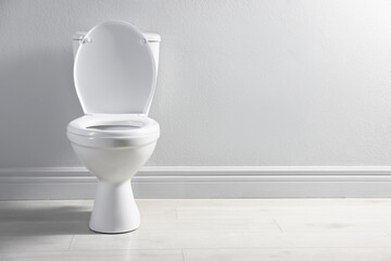 One toilet bowl near white wall indoors, space for text
