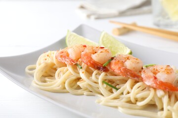 Delicious pasta with shrimps and green onions on white table, closeup
