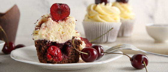 Plate with cut sweet cherry cupcake and berries on white background