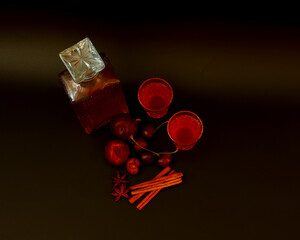 Plum-cherry liqueur with cinnamon and anise on a black background, a drink in a crystal decanter...