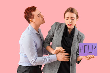Business woman holding paper with word HELP and her male colleague on pink background. Harassment concept
