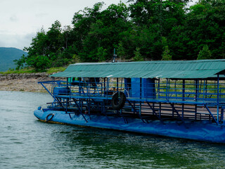 Local ferry transporting cars, motorcycles and people across a river in Kanchanaburi Province, Thailand.