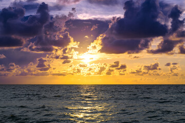 Obraz premium Dramatic sky and sun rays. Stormy cloud sky. Clouds above ocean. Dark cloudy sky at sunset background. Cloud sky with sea background.