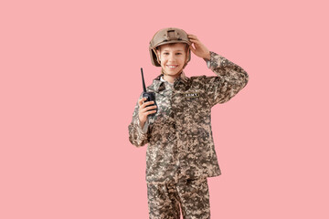 Teenage soldier with walkie-talkie on pink background