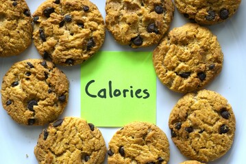 chocolate chip cookies on withe background with a Calorie text written on a sticky note